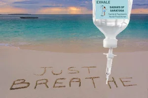 Exhale - beach with "Just Breathe" written in sand