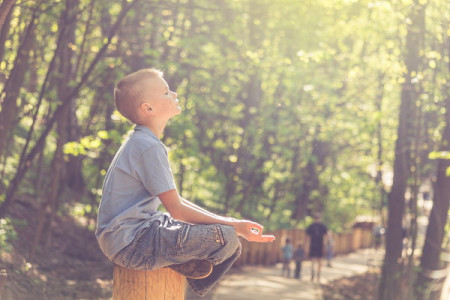 Boy sitting in sunlight with eyes closed